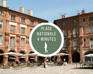 a large brick building with a woman standing in front of it at Les Loges de Montauban in Montauban