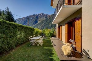 eine Reihe von Stühlen auf einer Veranda mit Bergen im Hintergrund in der Unterkunft Villa Mont Blanc in Chamonix-Mont-Blanc