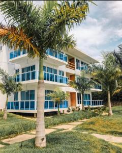 ein Gebäude mit Palmen davor in der Unterkunft JCS SEIJAS APARTAMENT Recidence and Beach Club, 3E in Pajarito