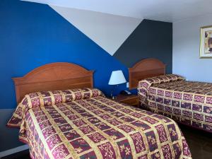 Habitación de hotel con 2 camas y pared azul en Royal Inn & Suites, en Knoxville