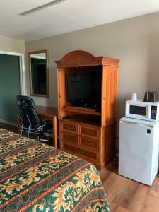 1 dormitorio con 1 cama, TV y microondas en Royal Inn & Suites, en Knoxville