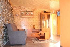 a living room with a chair and a table at Casa do Moinho Novo I in Fontão Fundeiro