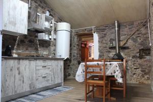 a kitchen with a table and chairs in a room at Casa do Moinho Novo I in Fontão Fundeiro +18 photos