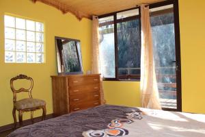 a bedroom with a bed and a dresser and windows at Casa do Moinho Novo I in Fontão Fundeiro