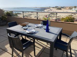 a table on a balcony with a view of the beach at Marfolín 28 in Cotillo