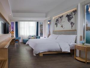 um quarto com uma cama grande e uma sala de estar em Kyriad Hotel Dongguan Dalingshan South Road em Dongguan