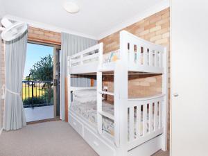 Letto a castello bianco in camera con balcone di Illawong 4 a Mooloolaba