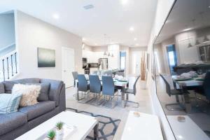 ein Wohnzimmer mit einem Sofa und einem Esszimmer in der Unterkunft New 4 BR 4 BA Villa Ground Zero to Theme Parks in Orlando