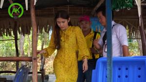 a young woman in a yellow dress standing next to two men at Motel Anh Kiệt - Vườn Quốc Gia Tràm Chim in Tràm Chim