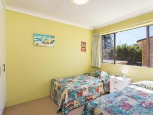 a bedroom with two beds and a window at Champagne Court 1 in Tuncurry