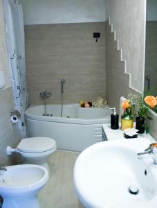 La salle de bains est pourvue de toilettes, d'une baignoire et d'un lavabo. dans l'établissement B&B Oro Puro, à Fondi