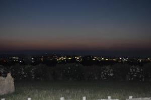 a cemetery at night with a city in the background at Villa Panorama in Moúdhros