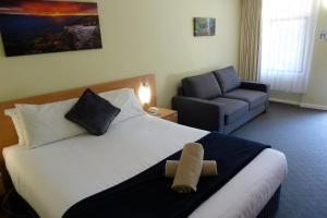 ein Hotelzimmer mit einem Bett und einem Stuhl in der Unterkunft Sky Rider Motor Inn in Katoomba