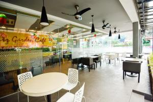a dining room with tables and chairs in a restaurant at Ritz Suites in Lumut