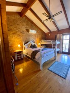 a bedroom with a white bed and a brick wall at Sabo’s On Severn in Fletcher