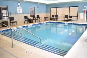 a large swimming pool with chairs and tables at Holiday Inn Express & Suites - Boston South - Randolph, an IHG Hotel in Randolph