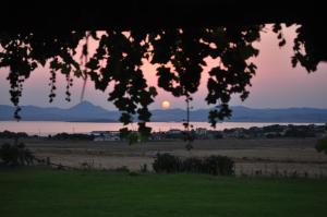 a view of a field with the sunset in the background at Villa Panorama in Moúdhros