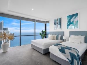 two beds in a room with a view of the ocean at Circle on Cavill - GCLR in Gold Coast