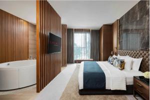 pokój hotelowy z łóżkiem i wanną w obiekcie Lancaster Bangkok w mieście Bangkok