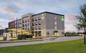 フリスコにあるHoliday Inn Express & Suites Dallas Frisco NW Toyota Stdm by IHGの道路沿いにある大きな建物