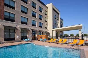 einem Pool vor einem Gebäude in der Unterkunft Holiday Inn Express & Suites Dallas Frisco NW Toyota Stdm, an IHG Hotel in Frisco