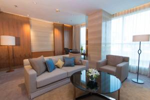 
a living room filled with furniture and a large window at Lancaster Bangkok - SHA Extra Plus in Bangkok
