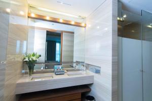 a bathroom with two sinks and a mirror at Lancaster Bangkok - SHA Extra Plus in Bangkok