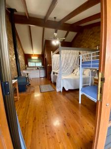 a bedroom with a bunk bed and a wooden floor at Sabo’s On Severn in Fletcher