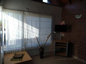 - un salon avec un vase et une fenêtre dans l'établissement La Loma, à Federación