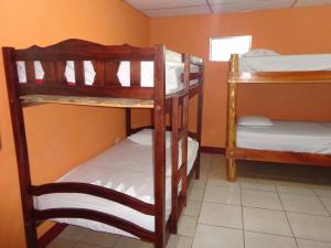 a room with three bunk beds and a window at Hostal Rancho Sabor Isleño - Ometepe in Altagracia