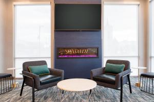 スポケーンにあるLa Quinta Inn & Suites by Wyndham Spokane Downtownの椅子2脚と暖炉付きの待合室