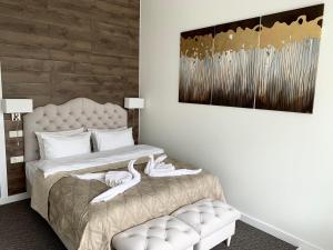 1 dormitorio con 1 cama con silla y 1 pintura en 7 Boutique Hotel, en Öskemen