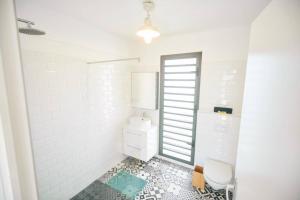 uma casa de banho branca com um WC e um lavatório em Villa Standing avec piscine, jardin, bord de mer em Saint-Gilles-les-Bains