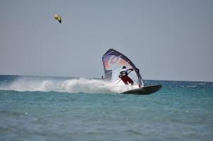 a person on a windsurfing board in the ocean at Villa Panorama in Moúdhros