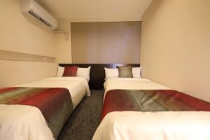 a room with three beds in a room at Terrace Garden Mihama Resort in Chatan
