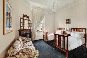 a living room with a couch and two beds at Langsford Luxury in Stawell