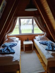 2 Betten in einem kleinen Zimmer mit Fenster in der Unterkunft Mien Leevsten in Carolinensiel