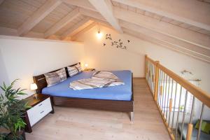 a bedroom with a blue bed in a attic at Ferienwohnung Allgäu-Füssen Landblick in Füssen