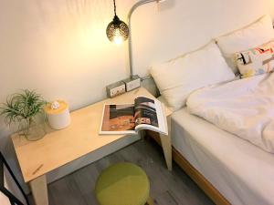 a room with a bed and a desk with a book at The Place in Hengchun South Gate
