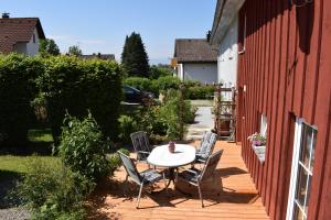 un patio con mesa y sillas junto a un edificio en Ferienwohnungen Dornröschen, en Weißensberg