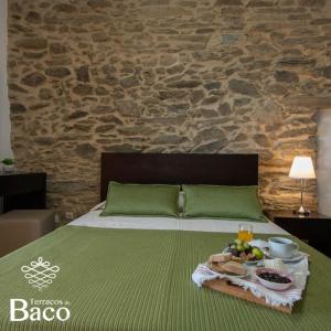 Ribalonga的住宿－Terraços de Baco，一张绿色的床,上面有盘子的食物