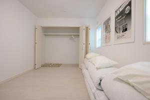 Dieses weiße Zimmer verfügt über ein Bett und einen Schrank. in der Unterkunft KOEI FARM LODGE -SEVEN Hotels and Resorts- in Kin