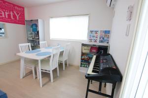 uma sala de jantar com uma mesa e um teclado em KOEI FARM LODGE -SEVEN Hotels and Resorts- em Kin