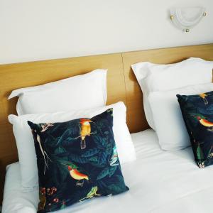 a bed with two pillows on it with at Brit Hotel Hermitage in Royan