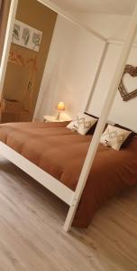 1 dormitorio con 1 cama grande y suelo de madera en Le cosy de sarah en Bordeaux-Saint-Clair