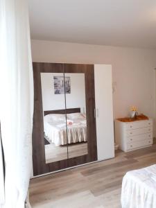 - un miroir dans une chambre avec un lit et une commode dans l'établissement Apartmani Kulin 2, à Kaštela