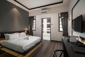 a bedroom with a bed and a desk and a television at Modern Hotel Georgetown in George Town