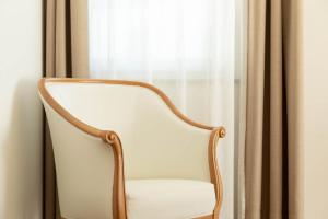 uma cadeira branca sentada em frente a uma janela em Landhaus am Gries em Lana