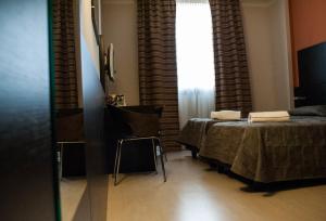 a bedroom with two beds and a window at Vercelli Palace Hotel in Vercelli