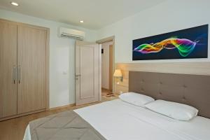 a bedroom with a bed with a tv on the wall at The Room Hotel & Apartments in Antalya
